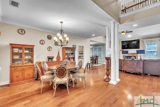 dining space featuring visible vents, ceiling fan with notable chandelier, light wood-type flooring, and decorative columns