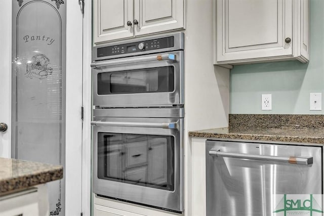 kitchen with stainless steel appliances, stone counters, and white cabinets