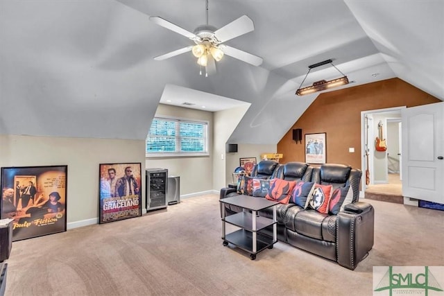 carpeted home theater room featuring vaulted ceiling, beverage cooler, a ceiling fan, and baseboards