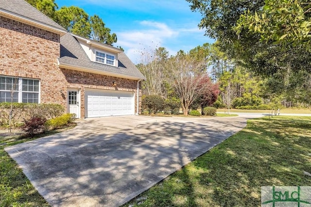 view of property exterior featuring brick siding, a shingled roof, a lawn, an attached garage, and driveway