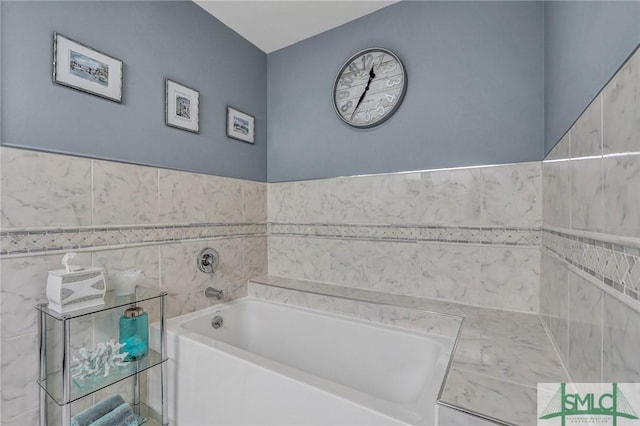 bathroom with tile walls and a bath