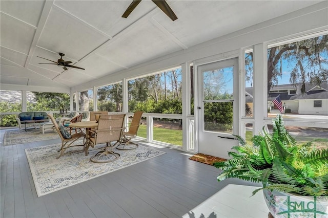 unfurnished sunroom with lofted ceiling and a ceiling fan