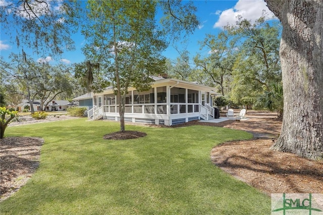 view of front of property featuring a patio, a front yard, and a sunroom