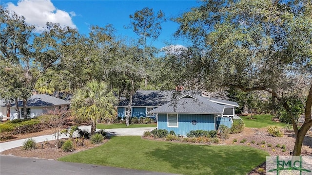 ranch-style home featuring driveway and a front lawn