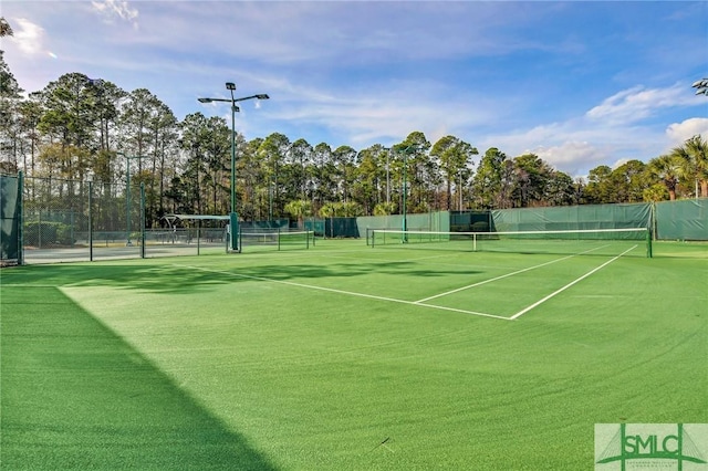 view of tennis court featuring fence