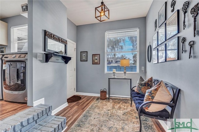 interior space featuring wood finished floors, washing machine and clothes dryer, and baseboards