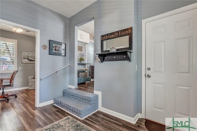 foyer featuring baseboards and wood finished floors