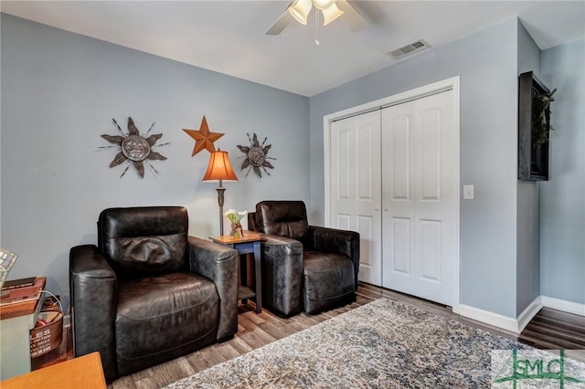 sitting room with visible vents, ceiling fan, baseboards, and wood finished floors