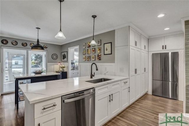 kitchen featuring stainless steel appliances, white cabinetry, a sink, and a peninsula