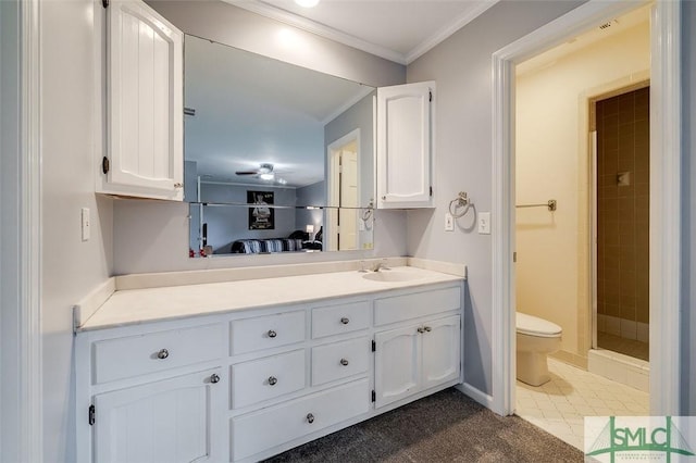 bathroom with toilet, ornamental molding, a stall shower, vanity, and baseboards