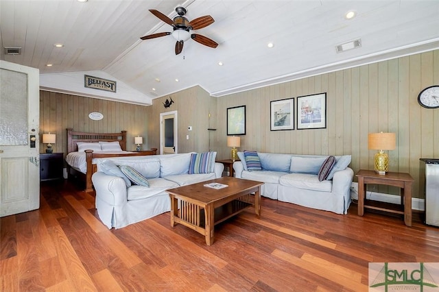 living room with vaulted ceiling, wood finished floors, and visible vents