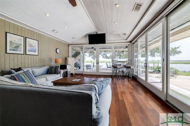 living area featuring lofted ceiling, visible vents, wood finished floors, and french doors