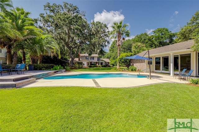 pool featuring a patio area and a lawn