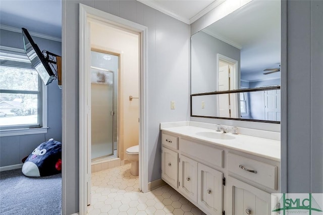 full bathroom featuring a stall shower, a ceiling fan, toilet, crown molding, and vanity