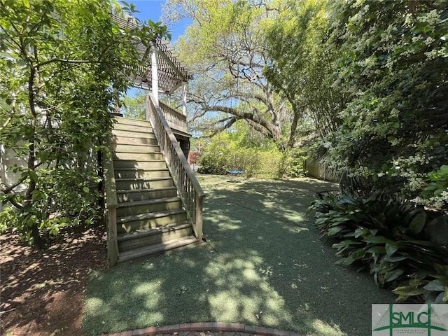 view of yard featuring fence and stairway