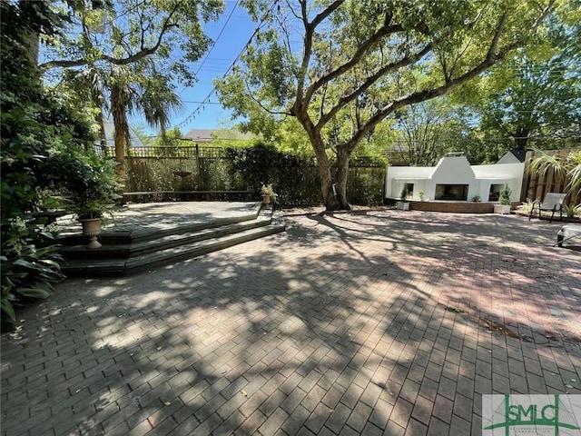 exterior space featuring a fenced backyard and an outdoor fireplace