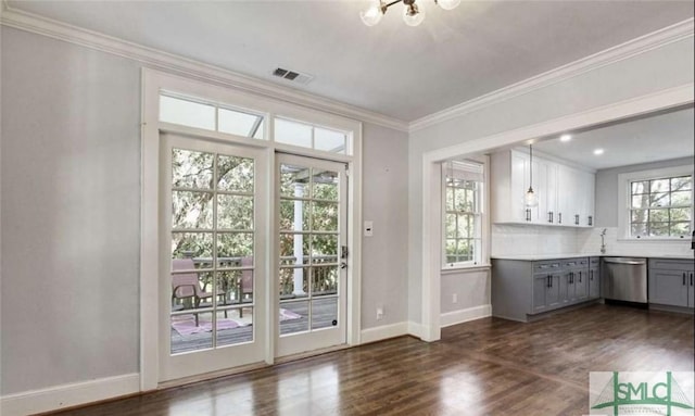 doorway with visible vents, baseboards, dark wood-type flooring, and ornamental molding