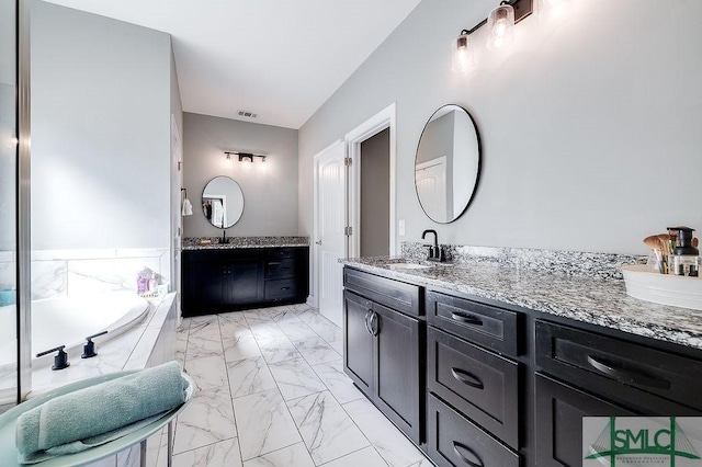 full bathroom featuring a sink, visible vents, marble finish floor, a bath, and double vanity