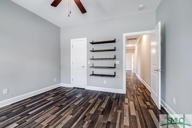 empty room featuring ceiling fan, wood finished floors, visible vents, and baseboards