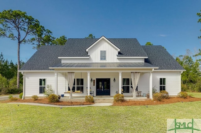 modern farmhouse with a standing seam roof, metal roof, a front lawn, and roof with shingles