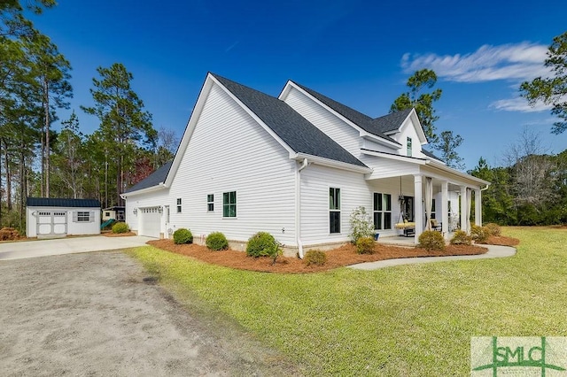 view of side of property with a garage, a storage shed, driveway, a yard, and a porch