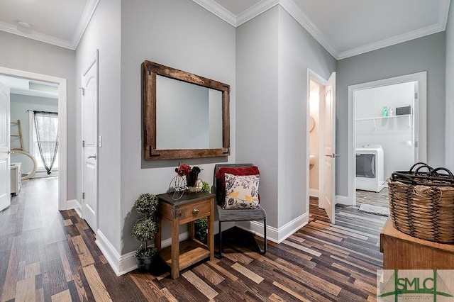 hallway with ornamental molding, washer / clothes dryer, dark wood finished floors, and baseboards