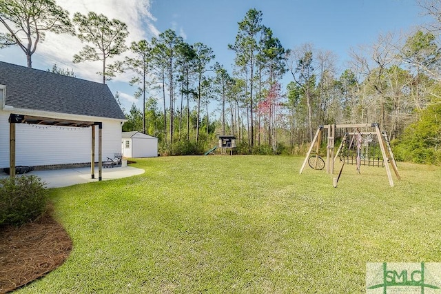 view of yard featuring an outbuilding, a patio area, a storage unit, and a playground