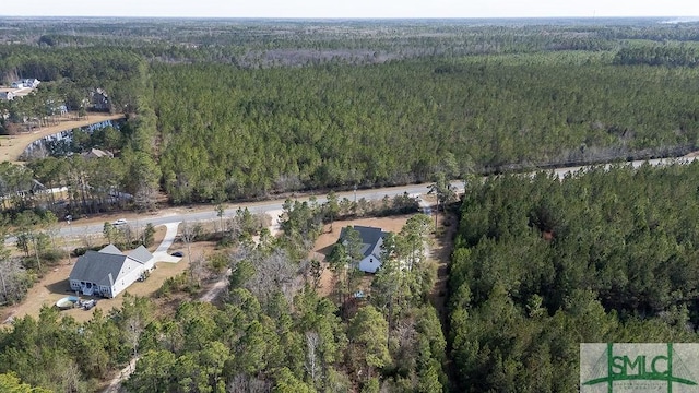 drone / aerial view with a wooded view