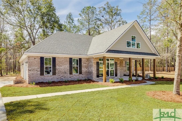 view of front of property featuring brick siding, a front lawn, and roof with shingles