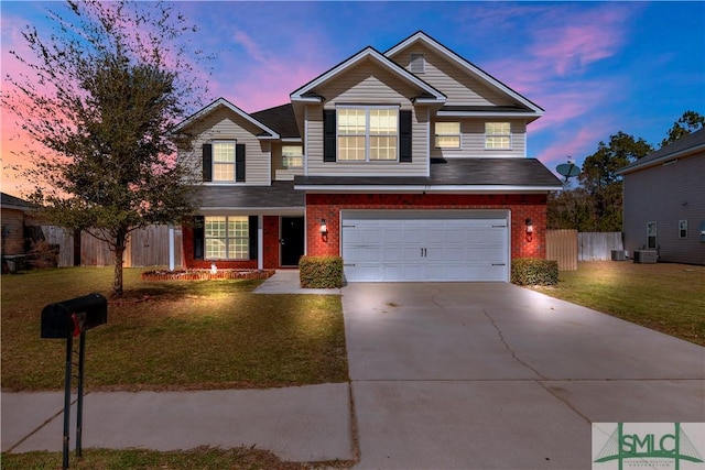 traditional-style home featuring a yard, fence, concrete driveway, and brick siding