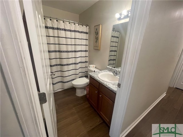 bathroom with toilet, a shower with curtain, wood finished floors, and vanity