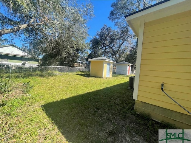 view of yard featuring a shed, fence, and an outdoor structure