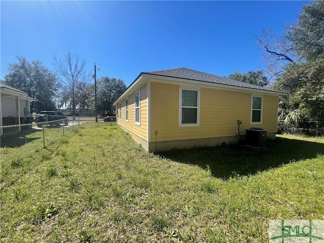 view of side of home with a yard, fence, and central air condition unit