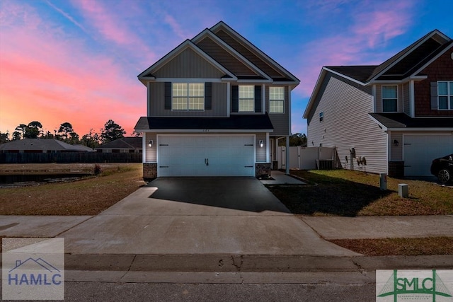 craftsman house with central AC unit, an attached garage, fence, driveway, and board and batten siding