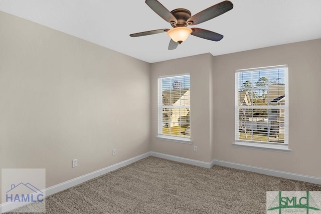 carpeted empty room with a ceiling fan and baseboards