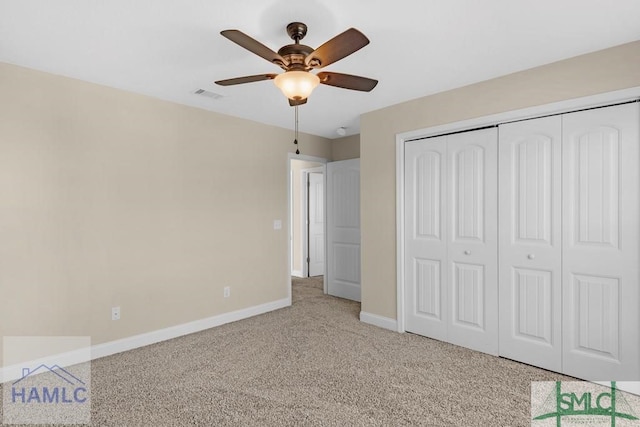 unfurnished bedroom with a closet, light colored carpet, visible vents, ceiling fan, and baseboards