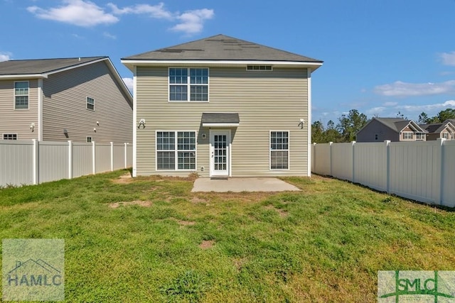 rear view of house with a yard, a patio area, and a fenced backyard