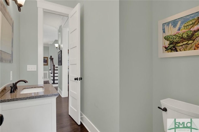 bathroom featuring wood finished floors, vanity, and baseboards