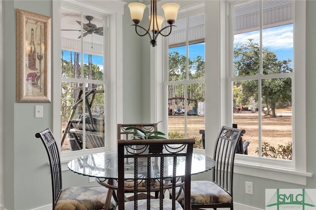 dining area featuring ceiling fan with notable chandelier