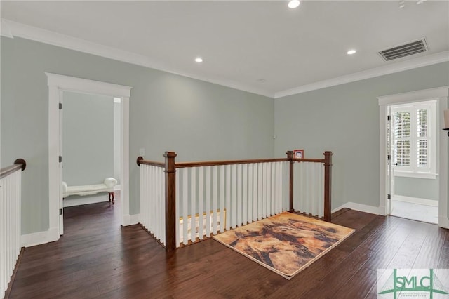 hall with visible vents, ornamental molding, wood-type flooring, and an upstairs landing