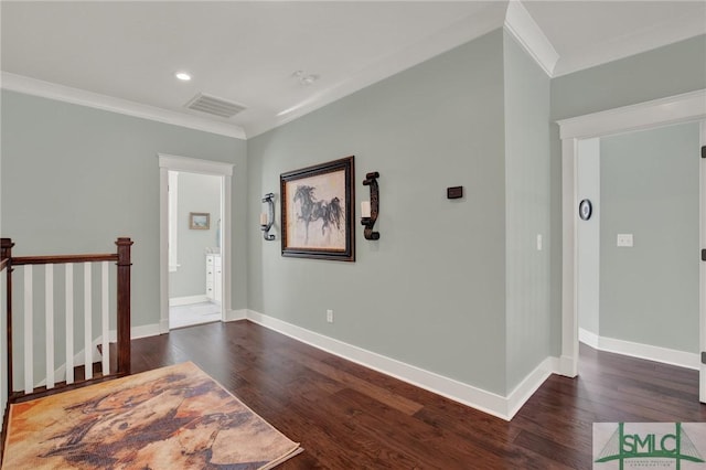 interior space featuring baseboards, wood finished floors, visible vents, and crown molding