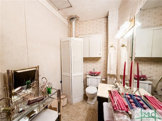 bathroom featuring toilet, wallpapered walls, tile patterned flooring, and vanity
