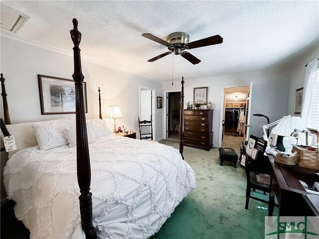 bedroom with visible vents, a spacious closet, a ceiling fan, light carpet, and a textured ceiling