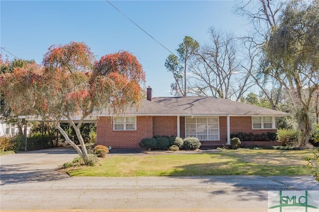 single story home with a carport, a front yard, brick siding, and a chimney