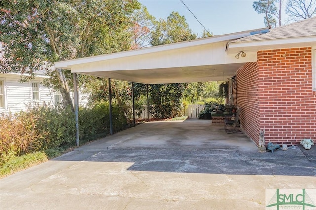 view of parking / parking lot featuring driveway and a carport