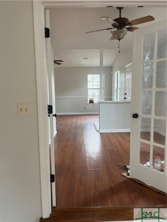 unfurnished room with lofted ceiling, a ceiling fan, baseboards, and wood finished floors