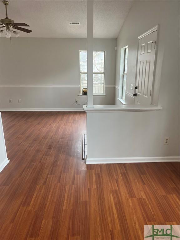 spare room with baseboards, a textured ceiling, visible vents, and wood finished floors