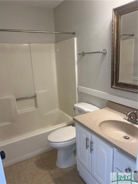 bathroom with toilet, bathing tub / shower combination, vanity, and tile patterned floors