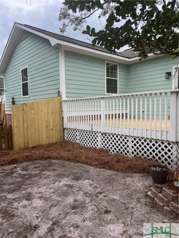 view of property exterior featuring a deck and fence