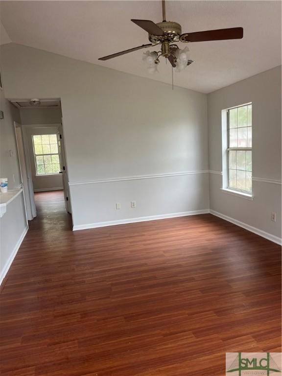 spare room with lofted ceiling, baseboards, and wood finished floors